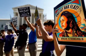 Members of the Native American coalition Apache Stronghold hold protest cards ahead of formally asking the Supreme Court to overturn an earlier ruling allowing the development of the Resolution Copper mine in Oak Flat, Ariz., outside the court in Washington Sept. 11, 2024. (OSV News/Piroschka van de Wouw, Reuters)